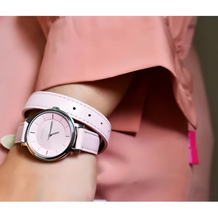 Close-up of a woman's wrist wearing a stylish pink Casio watch, complemented by a matching pink top.