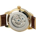 En närbild av baksidan på en Stuhrling-klocka, som visar de intrikata kugghjulen och rörelserna genom ett transparent hölje, på ett brunt armband.