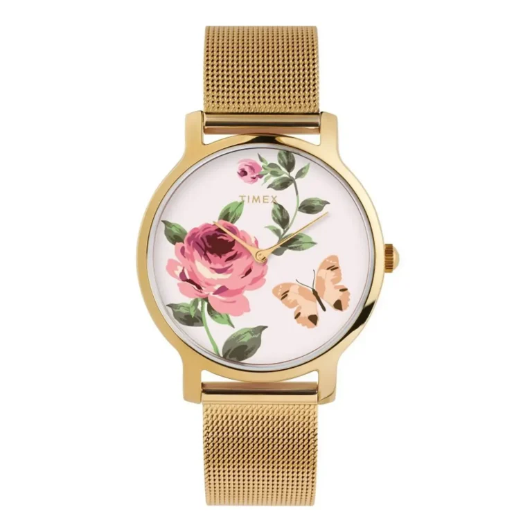 A gold-tone Timex watch with a floral design, featuring a pink rose and a butterfly on a white face, set on a mesh band.