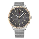 TOMMY HILFIGER 1791466 Meeste Tommy Hilfiger käekell tumehalli numbrilauaga, kuldse aktsendiga ja hõbedase võrkketiga. Stiilne tahhümeetri ja kuupäeva/nädalapäeva näidikuga.