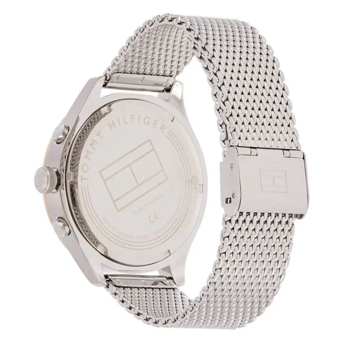 Sidabrinis Tommy Hilfiger laikrodis su tinkline apyranke; galinėje dalyje yra prekės ženklo logotipas ir informacija apie nerūdijančio plieno medžiagą.