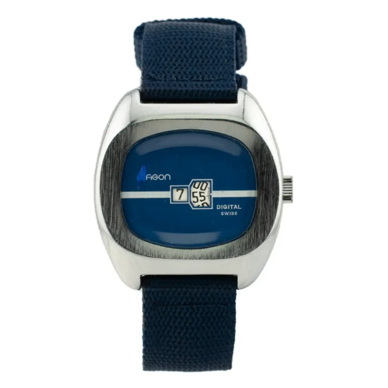 Vintage digital watch with a blue face, silver metal case, and navy fabric strap displaying time as "7:55". Swiss design.