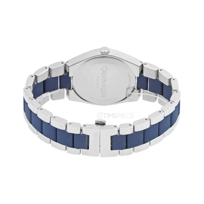 Close-up of a Calvin Klein watch featuring a silver case and a blue rubber strap, showcasing its sleek design and branding.