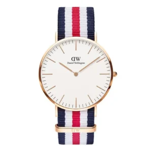 A stylish Daniel Wellington watch featuring a white face, gold hands, and a navy, red, and white striped fabric strap.