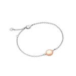 A delicate silver bracelet featuring a rose gold circular charm with engraved details, secured with a lobster clasp.
