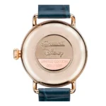 The back of a limited edition Ingersoll Disney watch, showcasing "001/500" engraving and a gold-tone finish with a blue leather strap.