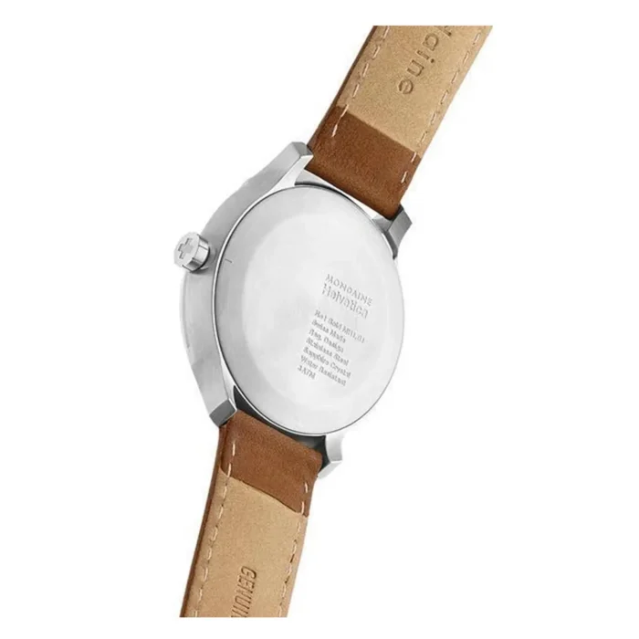 Close-up view of a Mondaine watch back showcasing a stainless steel case and a tan leather strap with engraved details.