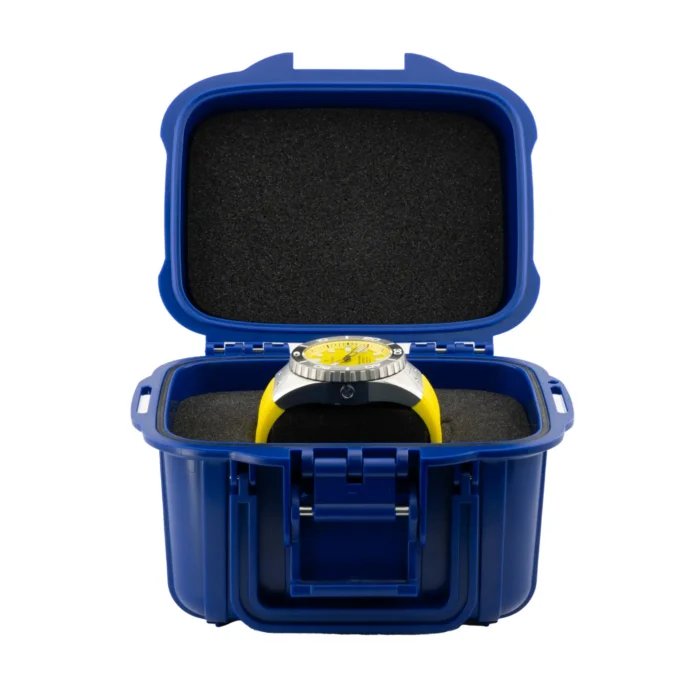 A vibrant yellow watch is displayed inside a blue protective case with a foam interior, showcasing its sleek design and durability