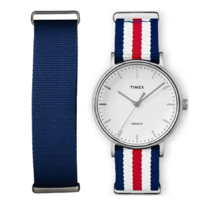 A Timex watch with a white face and silver hands, paired with two interchangeable straps: navy blue and a striped design with red, white, and blue.