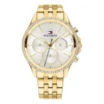 Gold-tone Tommy Hilfiger watch with crystal details, white face, three sub-dials, and a metal link bracelet. Elegant and stylish design.