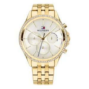 Gold-tone Tommy Hilfiger watch with crystal details, white face, three sub-dials, and a metal link bracelet. Elegant and stylish design.