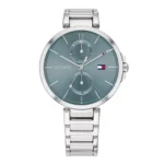 A sleek silver Tommy Hilfiger watch with a blue dial, featuring date and day indicators, and a modern bracelet design.