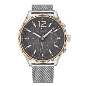 Men's Tommy Hilfiger wristwatch featuring a dark grey dial, gold accents, and a silver mesh strap. Stylish with a tachymeter and day/date functions.