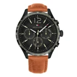 Black and gold Tom Hilfiger watch with a tachymeter, featuring three sub-dials and a brown leather strap. Stylish and modern design.