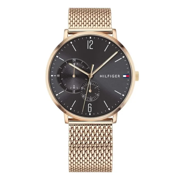 A stylish gold mesh strap watch with a black dial, featuring minimalist hour markers and sub-dials, by Tommy Hilfiger.