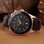 A stylish Trussardi automatic watch with a black dial, rose gold accents, and a brown leather strap, set against a textured background.