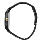 A sleek black wristwatch with a gold crown detail, showcasing its minimalist design and adjustable link band from a side profile.